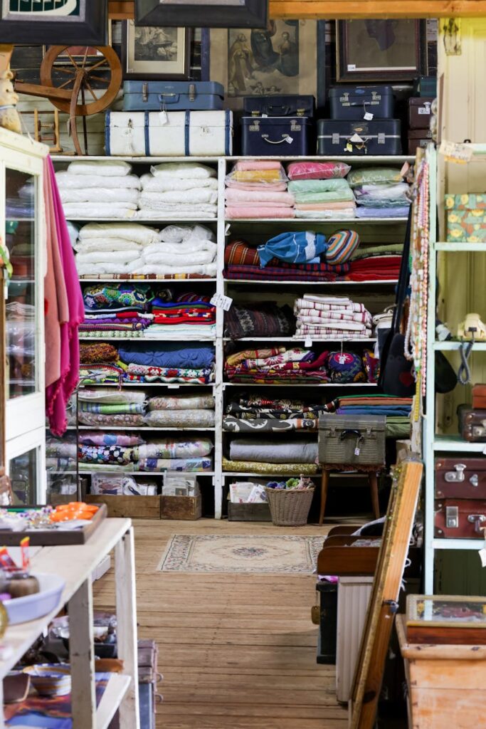 Colorful fabrics and vintage suitcases neatly arranged in a rustic store interior.